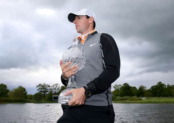 AT LAST: Rory McIlroy gets his hand on the Irish Open trophy after three years of poor performances. The world No 3 will donate his first prize of Â£515,000 to his own foundation. Picture: Brian Lawless/PA