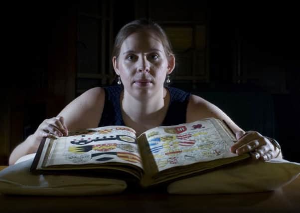 Rebecca Dowd, data migration assistant at Leeds University Special Collections, with a heraldic manuscript of the Horseley Family of York from 1659; and among the  archives. Picture: James Hardisty