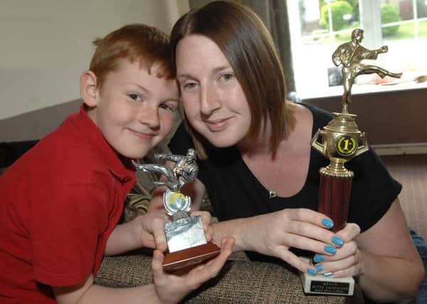 Liza Leeson with her son Oliver Robinson and some of her karate trophies from 2003