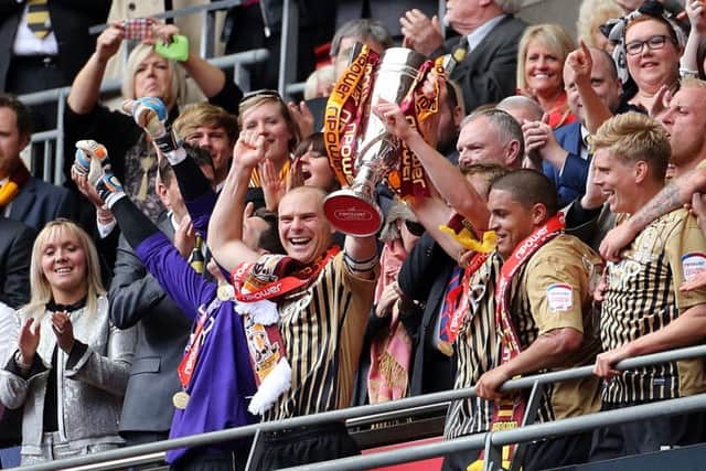 Bradford City captain Gary Jones (centre) and his team-mates celebrate after winning the League Two play-off trophy in 2012. Picture: Gareth Fuller/PA.
