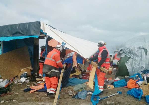 Handout file photo taken with permission from the Twitter feed of @HelpRefugeesUK of demolition teams dismantling makeshift homes in the Calais migrant camp known as the Jungle.