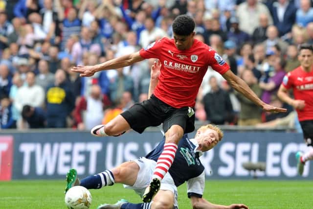 Barnsley 's Ashley Fletcher is tackled by Millwall's Chris Taylor.  Picture Tony Johnson
