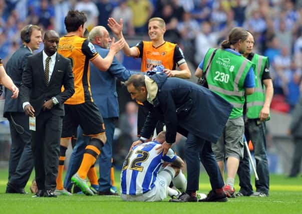 Wednesday manager Carlos Carvalhal consoles  Jack Hunt as Hull celebrate promotion. (Picture: Tony Johnson)