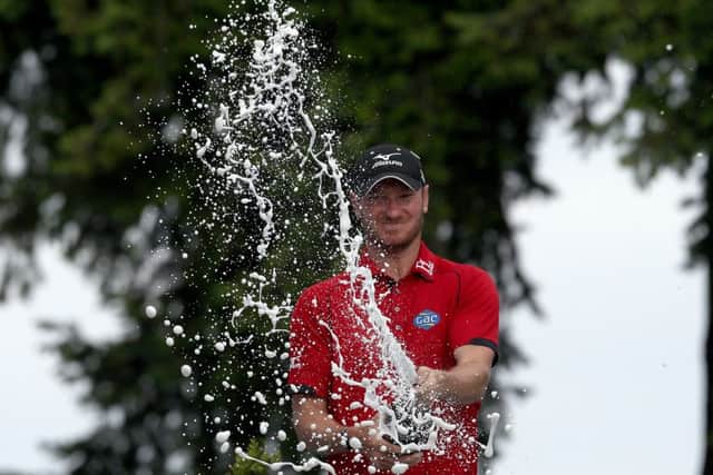 England's Chris Wood celebrates with champagne after winning the BMW PGA Championship at Wentworth. Picture: Steve Paston/PA.