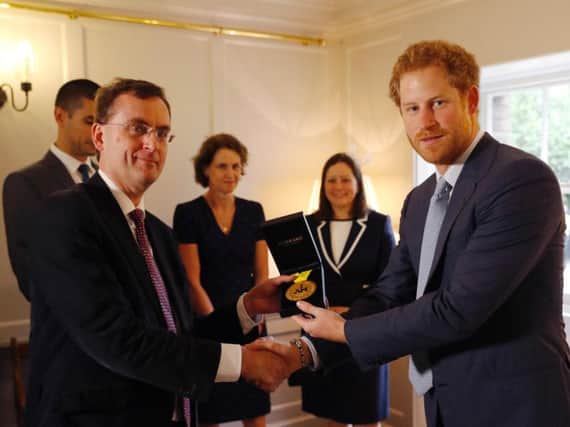 Prince Harry (right) hands over an Invictus Games gold medal won by Elizabeth Marks to consultant intensivist Dr Alain Vuylsteke, originally from Belgium, and the other members of the Papworth Hospital medical team who helped save the servicewoman's life, as they visit Kensington Palace in London.Picture: Matt Dunham/PA Wire