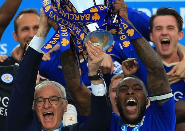 Leicester City captain Wes Morgan and manager Claudio Ranieri lift the trophy as the team celebrate winning the cash-rich Premier League