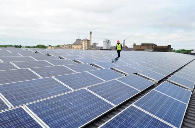 A worker checks the solar panels on the roof of Heineken's Tadcaster Brewery. Picture : Jonathan Gawthorpe