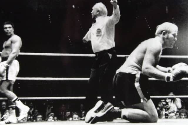 Richard Dunn raises his fists in desperation after being knocked down for the second time in his heavyweight world title fight against Muhammad Ali. Dunn lost the fight in the fifth round after a technical knockout.