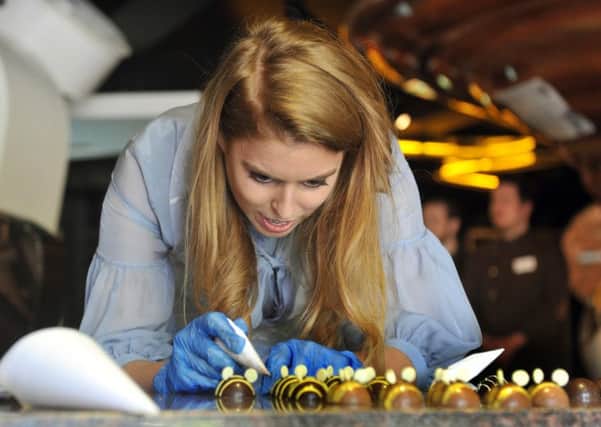 Princess Beatrice tries her hand at icing some chocolate bees at Yorkshire Chocolate Story. (GL1010/37b)
