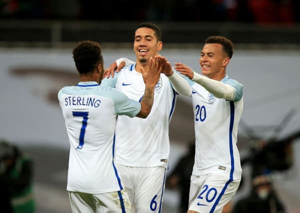 England's Chris Smalling (centre) celebrates scoring his side's first goal of the game with team-mates Raheem Sterling (7) and Dele Alli (20) during an International Friendly at Wembley Stadium, London.