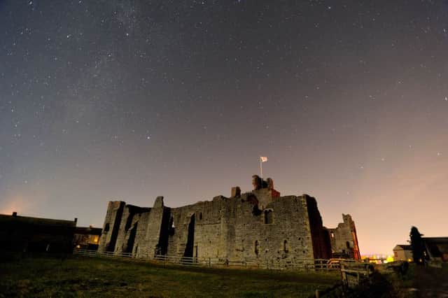 Middleham Castle under the stars lit by the light of a half moon.  Picture by Bruce Rollinson