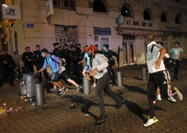 Local youths run after being chased by England supporters in downtown Marseille after they clashed ahead of Saturday's European Championship match between England and Russia at the Stade Velodrome.(AP Photo/Darko Bandic)