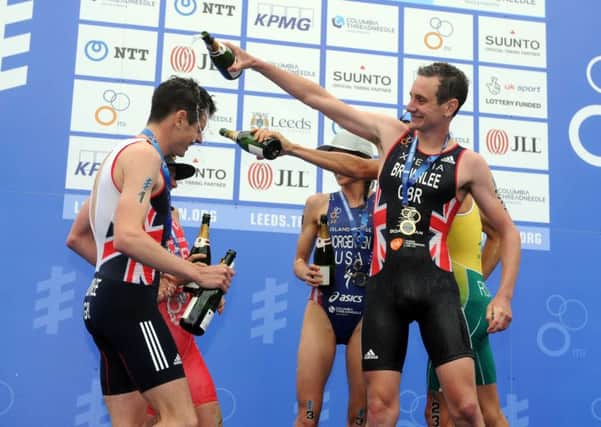 PARTY TIME: Alistair Brownlee celebrates his win of the 2016 ITU World Triathlon Leeds by soaking his brother Jonny in champagne on the podium in Millenium Square.  Picture: Tony Johnson.