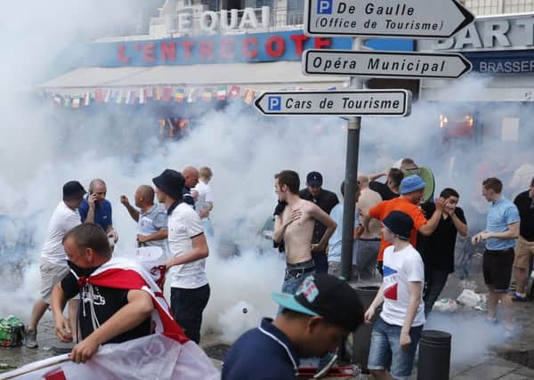 England supporters take evasive action after French police fired tear gas at them in downtown Marseille on Friday. (AP Photo/Darko Bandic)