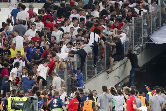 Spectators try to escape from the stands as clashes break out right after the Euro 2016 Group B soccer match between England and Russia, at the Velodrome stadium in Marseille