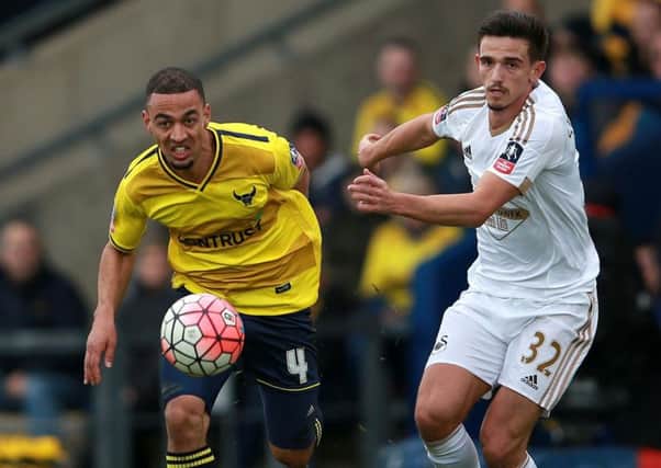 Oxford United's Kemar Roofe, left, seen in action against Swansea City in the FA Cup.