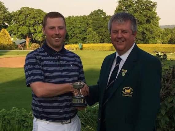 Cleckheaton's Nigel Colbeck receives the Bradford 36-hole amateur championship trophy from union president Colin Edwards, of Northcliffe.