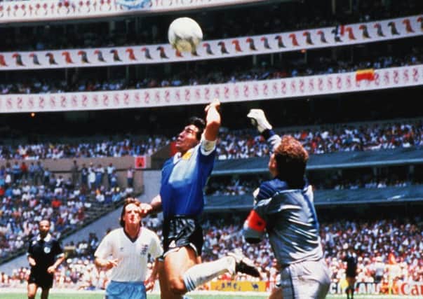 Argentinas Diego Maradona jumps with an outstretched left arm to score the infamous  Hand of God goal in the World Cup quarter-final against England goalkeeper Peter Shilton in Mexico City in 1986 (Picture: Rex Features).