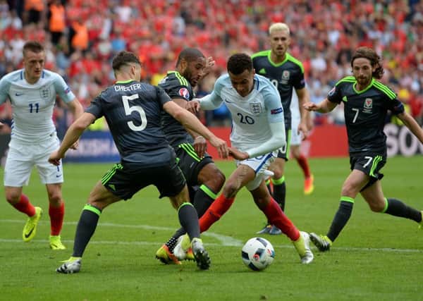 England's Dele Alli is tackled by Wales' Ashley Williams and James Chester during the UEFA Euro 2016, Group B match at the Stade Felix Bollaert-Delelis, Lens.