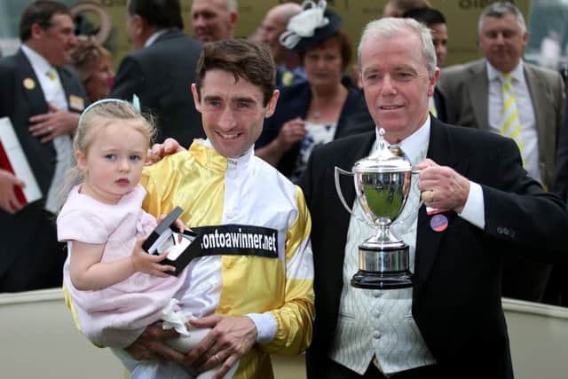 Jockey Dougie Costello, his daughter Aoife, and trainer Karl Burke (right) with the Commonwealth Cup after a winning ride on Quiet Reflection. Picture: PA.