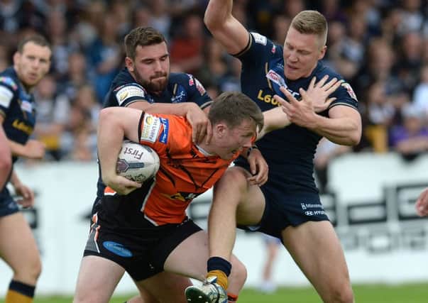 Castleford Tigers' Paddy Flynn is tackled by Hull FC's Josh Bowden (left) and Chris Green.
