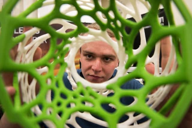 Jack Wilkinson examining a medical cell structure created  using the Universitys 3D printer in the robotics lab. Photo: Paul Ellener