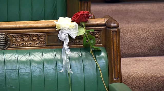A white and red rose lie on Jo Cox's empty seat in the House of Commons, London, as MPs gather to pay tribute to her.