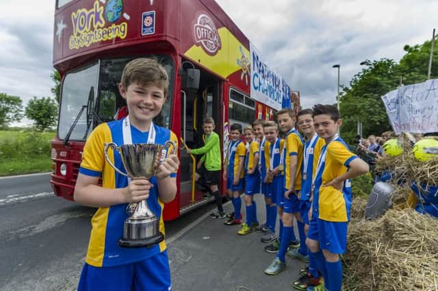 Barkston Ash Primary School football team celebrate becoming National Champions in the small schools category of the ESFA Danone Nations Cup, the worldÃ¢Â¬"s largest football tournament for 10-12 year olds by riding around the nearby villages on an open top bus. Picture James Hardisty.