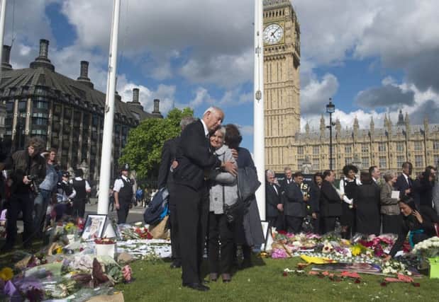 The parents of Jo Cox, Jean and Gordon Leadbeater, look at the flowers laid in memory of their daughter in Parliament Square, London.