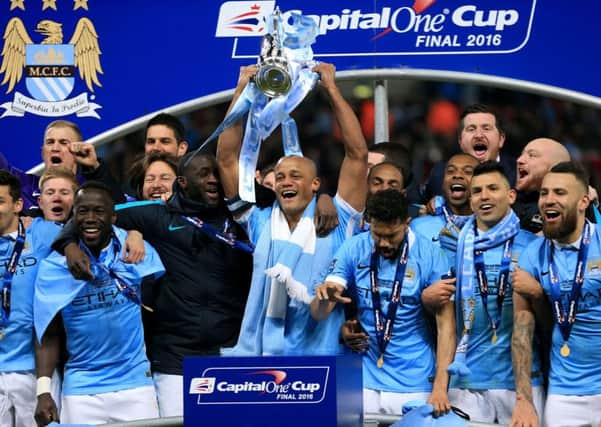 Manchester City's Vincent Kompany (centre) and team-mates celebrate with the trophy after victory in the Capital One Cup final at Wembley Stadium, London.