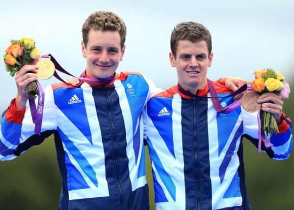 Alistair Brownlee celebrates with his gold medal and Jonathan Brownlee (right) celebrates with his bronze medal, after the Men's Triathlon at London 2012 Olympics. 
Picture: Mike Egerton/PA Wire