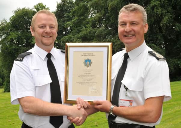 PC Sean Cannon receives his award Chief Fire Officer Simon Pilling. Picture: West Yorkshire Fire and Rescue Service.