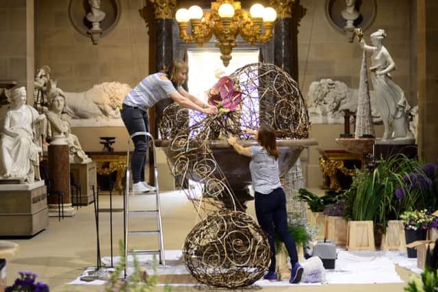 Volunteers Wendy Naylor and Tina Reddel help award winning floral designer Jonathan Moseley put the finishing touches to Florabundance flower show at Chatsworth. Picture Scott Merrylees