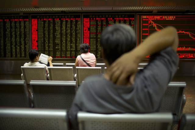 Chinese investors monitor stock prices at a brokerage house in Beijing this morning