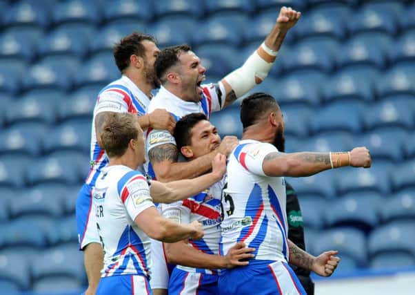 Wakefield's players celebrate with David Fifita after his opening try against Huddersfield (
Picture : Jonathan Gawthorpe).
