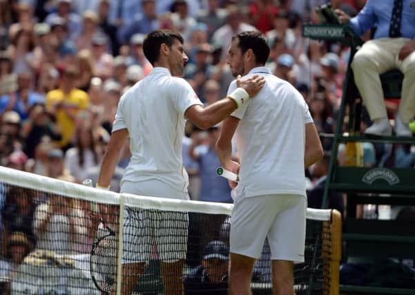 Serb Novak Djokovic, the defending champion, gives a consoling pat on the back to Jamie Ward after defeating the Briton at Wimbledon yesterday (Picture: Anthony Devlin/PA).