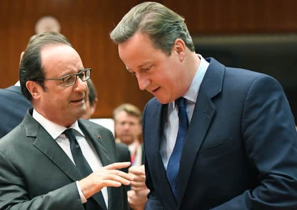 British Prime Minister David Cameron, right, speaks with French President Francois Hollande during a round table meeting at an EU summit in Brussels on Tuesday. (AP Photo/Geert Vanden Wijngaert)