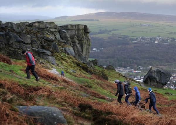 Walkers climb up onto Ilkley Moor past the Cow and Calf rocks.  Picture Bruce Rollinson