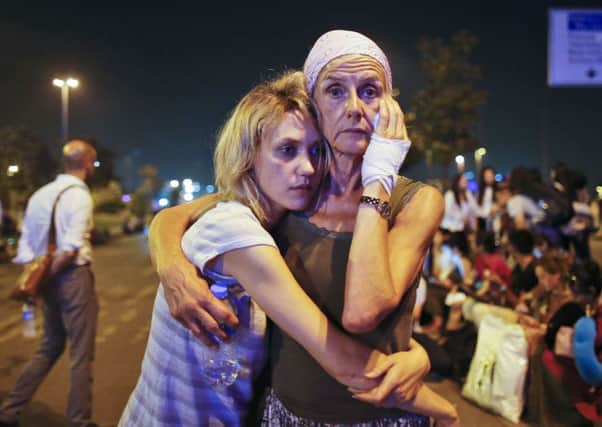 Passengers embrace each other as they wait outside Istanbul's Ataturk airport. Picture: AP Photo/Emrah Gurel