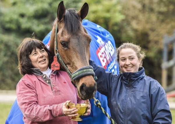 Coneygree eats from the Gold Cup as he is led around the Old Manor Stables by owner Sara, left, and daughter Lily Bradstock (Picture: PA).