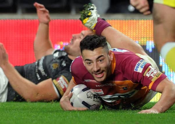 Jake Connor crosses for a try for Huddersfield. (Picture: Steve Riding).