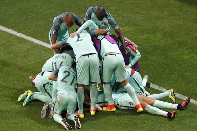 Portugal's Cristiano Ronaldo is congratulated by his teammates after scoring the opening goal. Picture: AP/Michael Sohn.