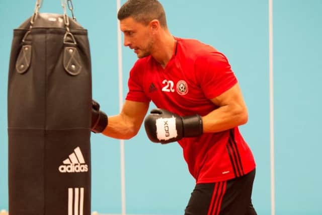 New Sheffield United defender James Wilson pounds the punchbag during a training session out of the ordinary for Blades players.
