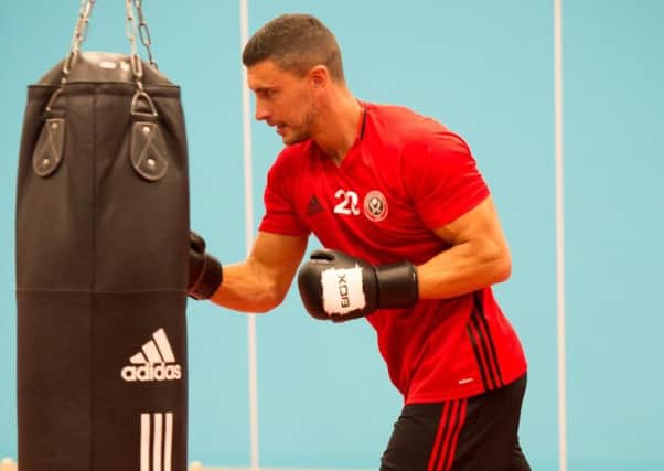 New Sheffield United defender James Wilson pounds the punchbag during a training session out of the ordinary for Blades players.