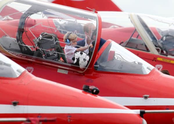 The Duke of Cambridge sits  Prince George in the cockpit of an RAF Arrow aircraft, during a visit to the Royal International Air Tattoo at RAF Fairford - the world's largest military airshow. Image: Chris Radburn/PA Wire