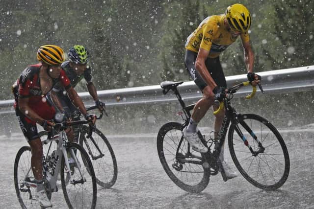 Britain's Chris Froome, wearing the overall leader's yellow jersey, Australias Richie Porte, left, and Colombias Nairo Quintana, second left, climb in pouring rain and hail towards Andorra Arcalis during the ninth stage. Picture: AP/Christophe Ena