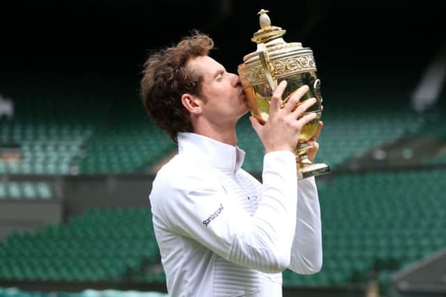 SHEER DELIGHT: Andy Murray poses for photographs on Centre Court at Wimbledon on Monday, the day after winning the Men's Singles trophy for a second time. Picture: Steve Paston/PA.