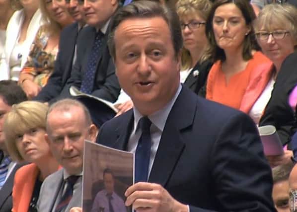 Prime Minister David Cameron holds up a picture of himself with Larry the cat during his last Prime Minister's Questions in the House of Commons, London. PA Wire