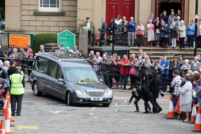 Mourners leave roses before the coffin of Labour MP Jo Cox passes in Batley, West Yorkshire, ahead of her private funeral service.