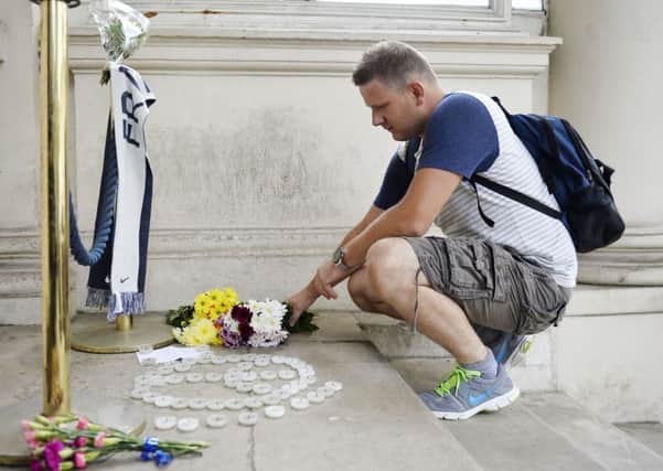 A man lays flowers outside the French Embassy in London, following the death of at least 84 people, including several children, after a terrorist drove a truck through crowds celebrating Bastille Day in Nice. Hannah McKay/PA Wire